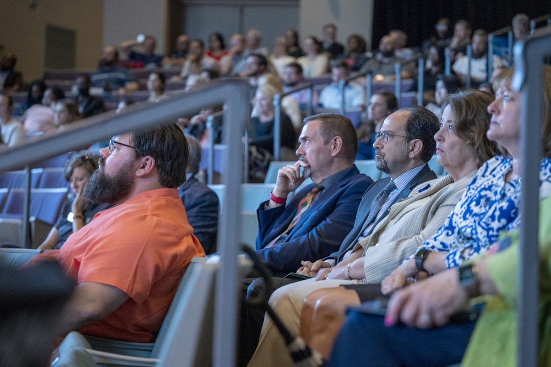 men and women listening in an auditorium