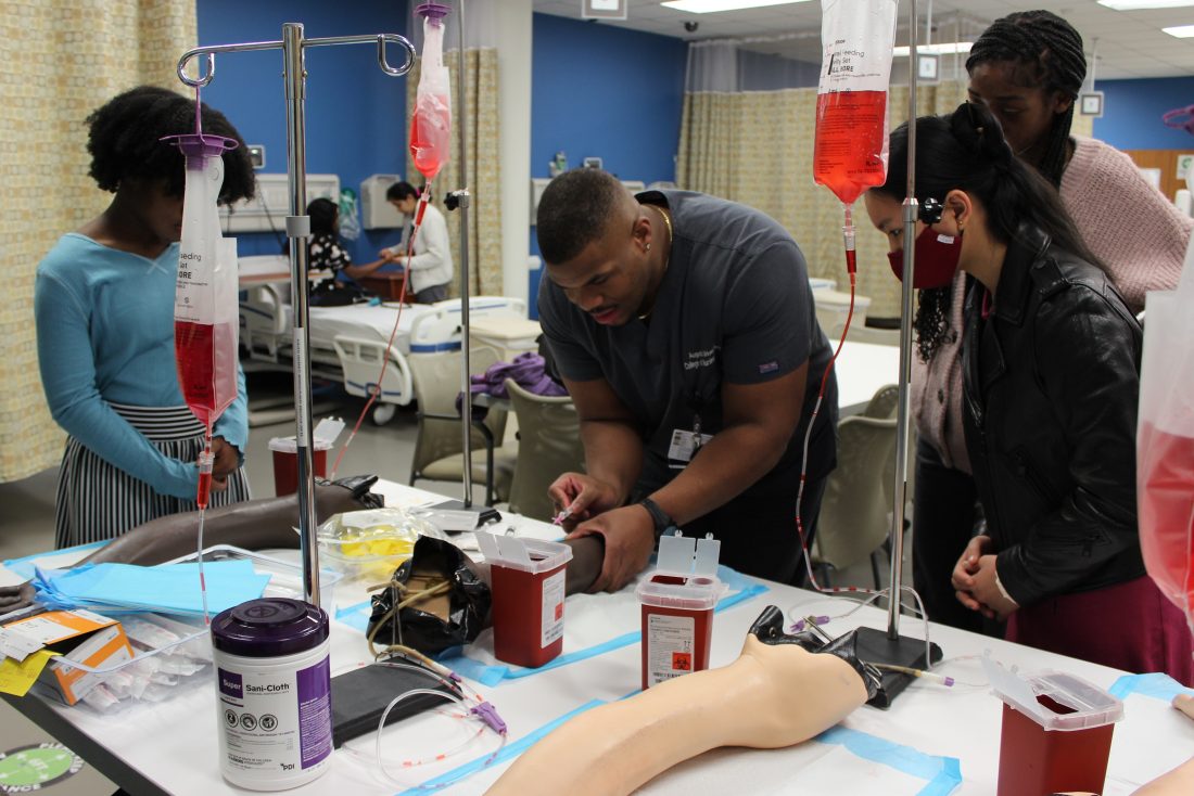 medical students working in a lab setting with IV training