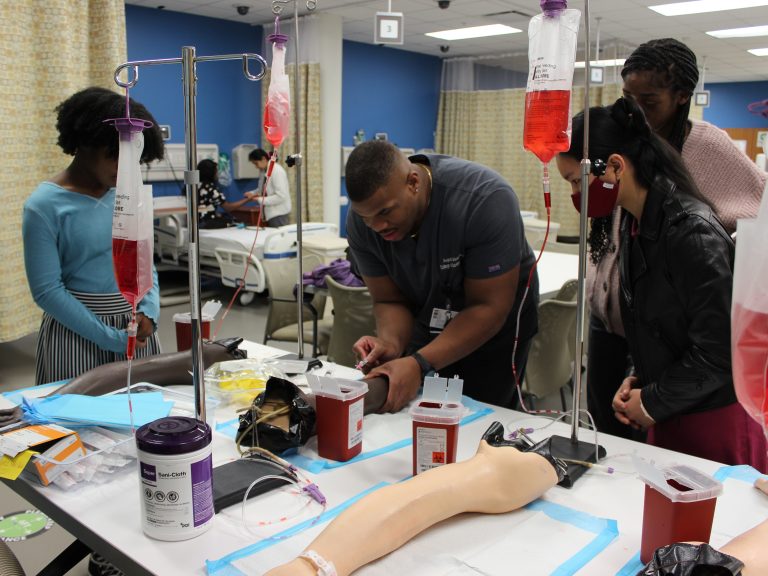medical students working in a lab setting with IV training