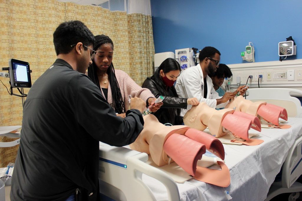 Medical students teaching younger students in a simulation center