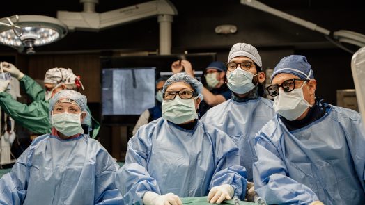 Doctors wearing scrubs and masks in operating room