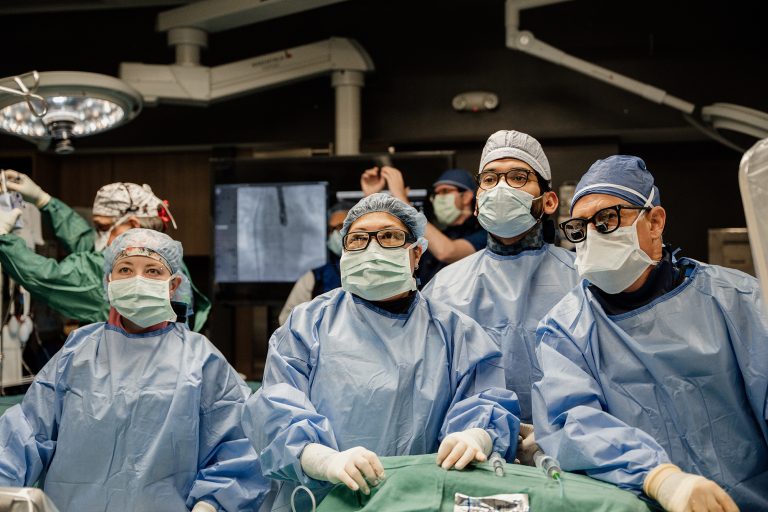 Doctors wearing scrubs and masks in operating room