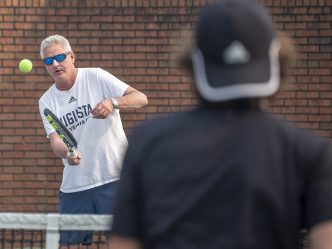 Men hitting tennis balls