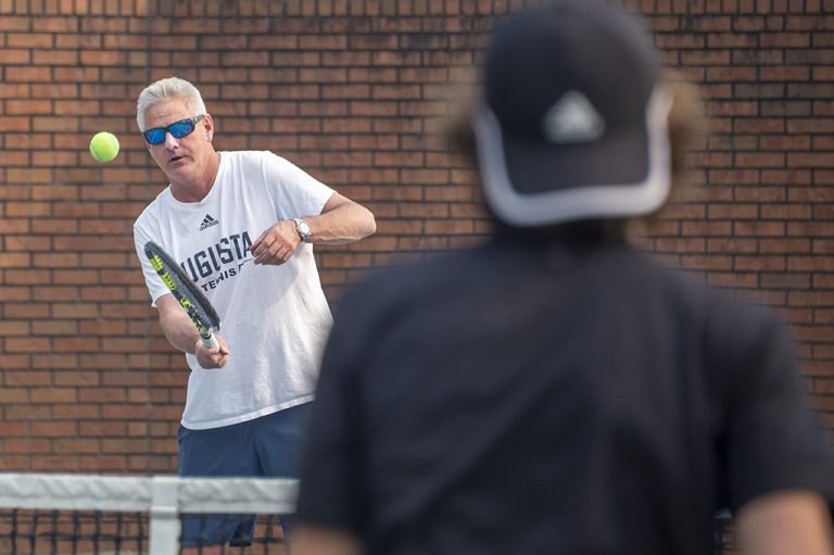 Men hitting tennis balls