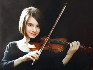 Young lady smiling and playing violin