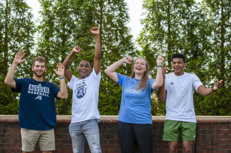 Four college students cheering