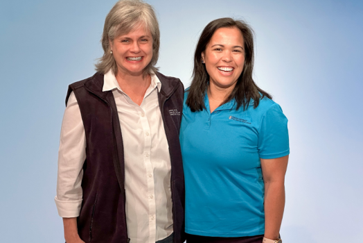 two women standing giving each other a shoulder hug