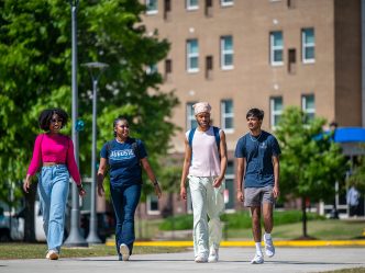 four students walk across campus