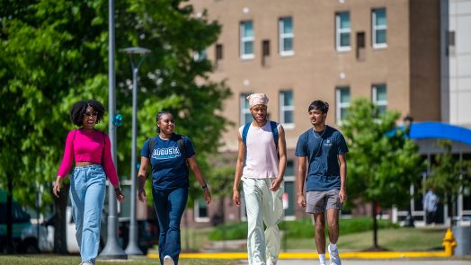 four students walk across campus