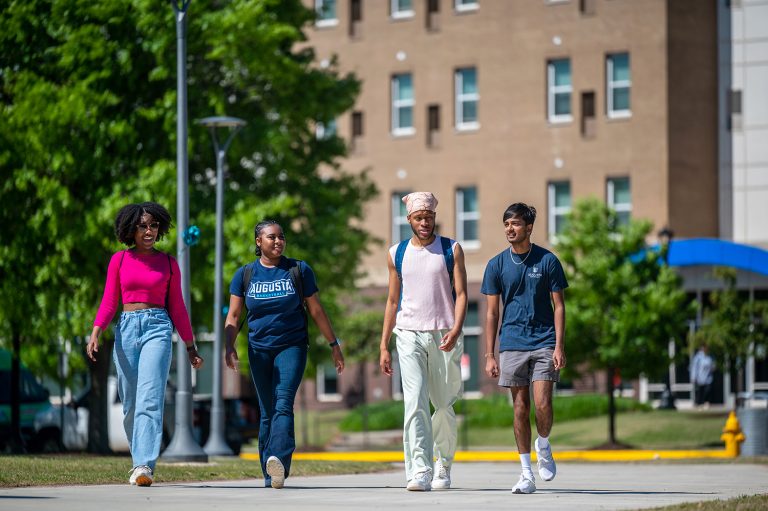 four students walk across campus