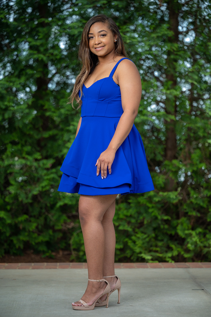 woman wearing a dress poses for a picture outside