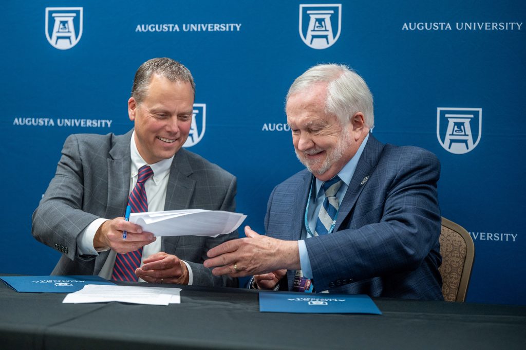 Two men smiling at press conference