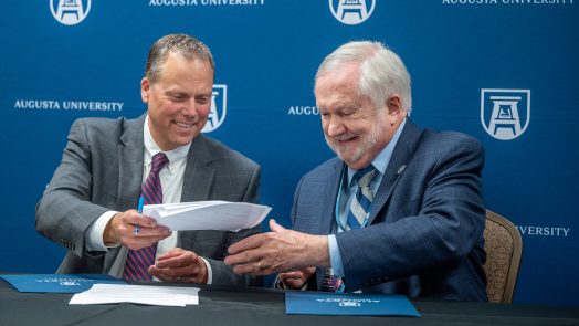 Two men smiling at press conference