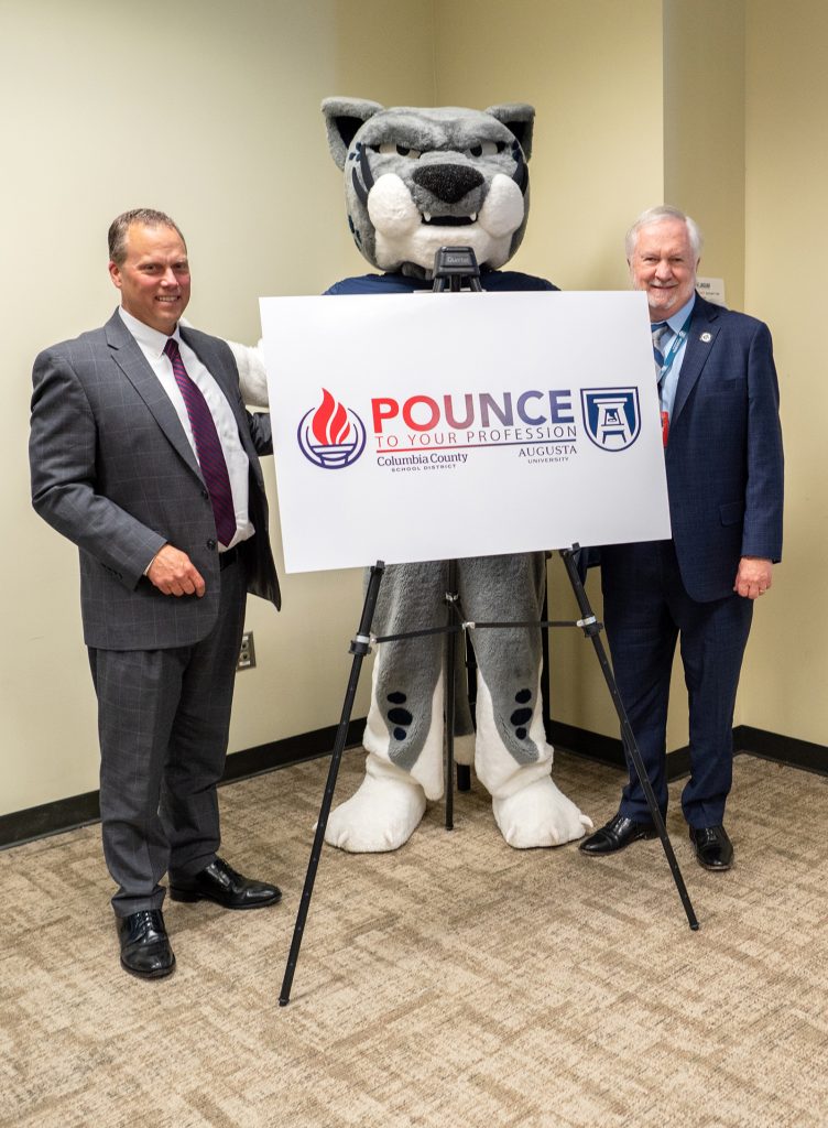 Men posing with mascot