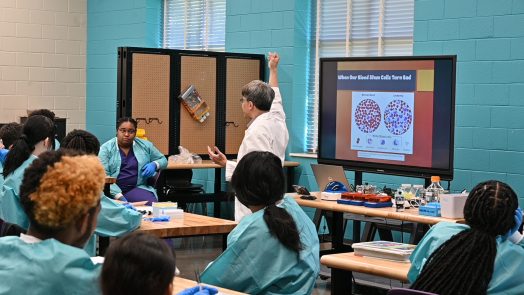 A professor teaches a classroom of students