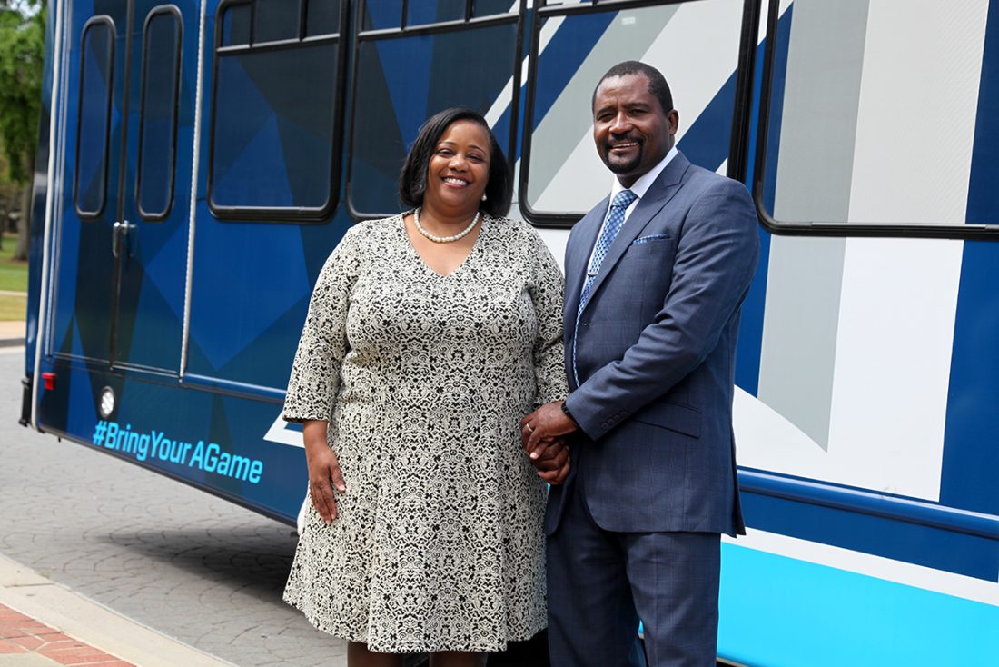 Smiling couple in front of bus