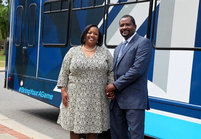 Smiling couple in front of bus