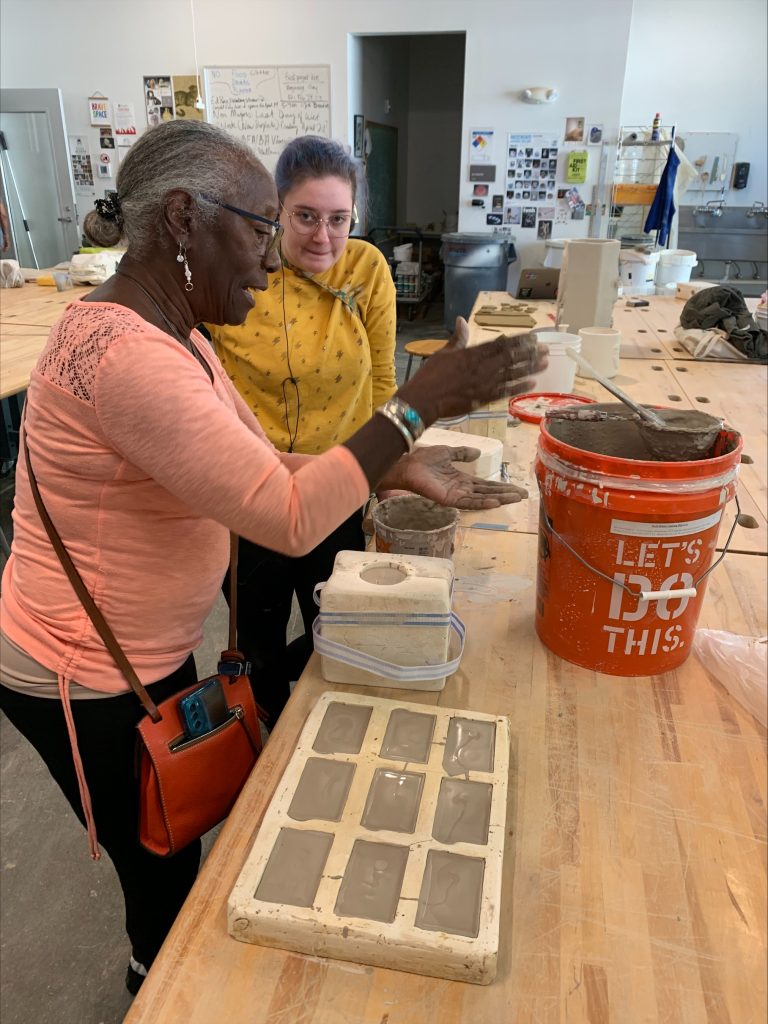 Older woman teaching a young woman about art