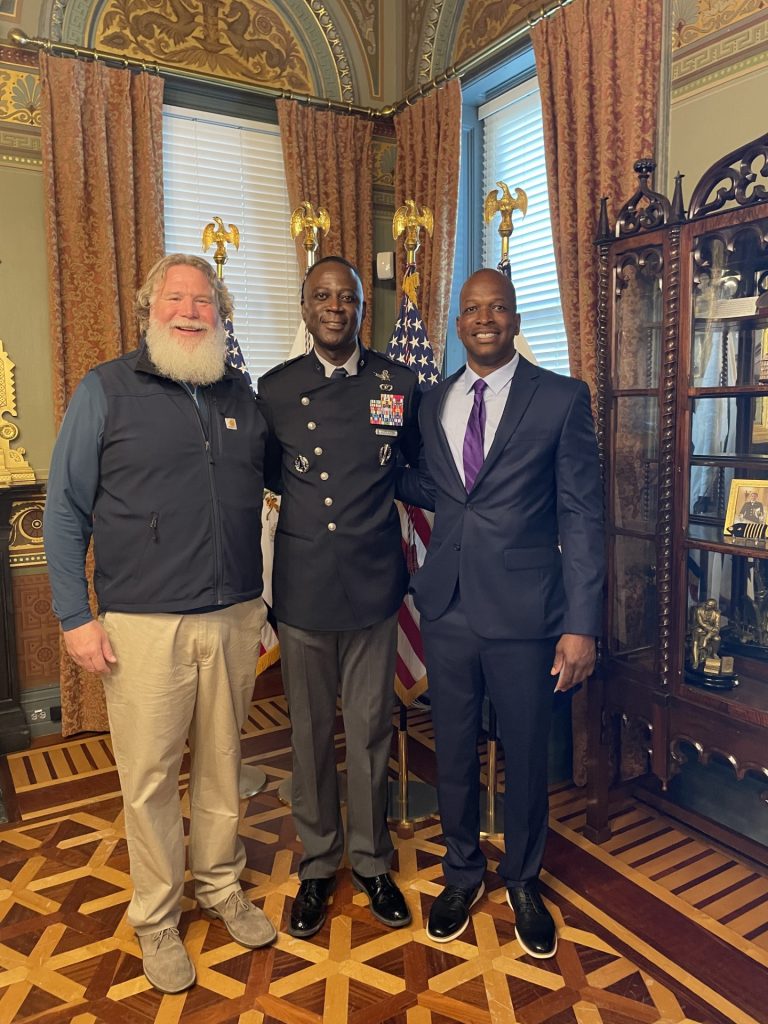 two men surround a man in uniform