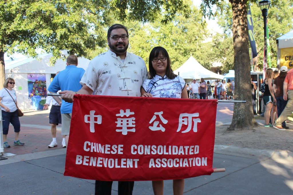 Man and woman standing with a banner.