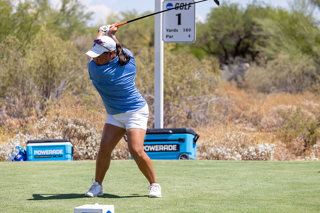 Woman swinging a golf club