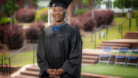 woman standing with her cap and gown on