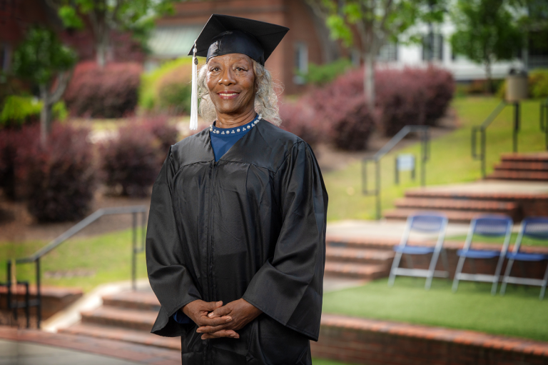 woman standing with her cap and gown on