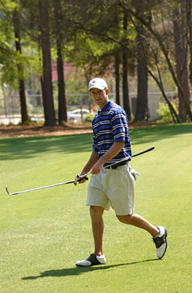 Man walking with golf clubs