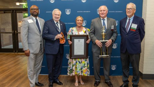 People smiling and holding awards