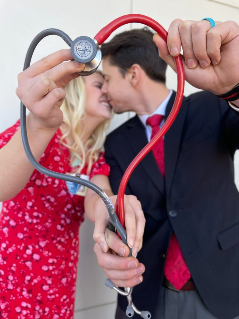 Man and women kiss in front of stethoscope 