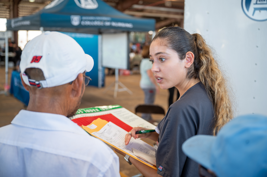 Health worker takes information from a patient in the field