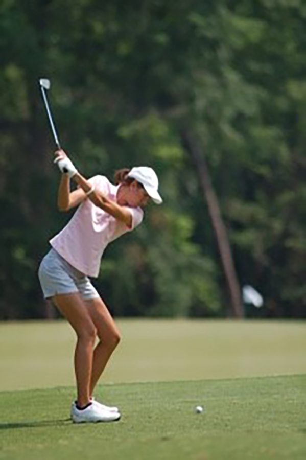 Woman swinging a golf club