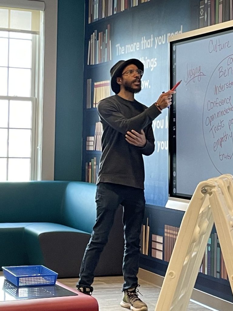 man teaches student at white board