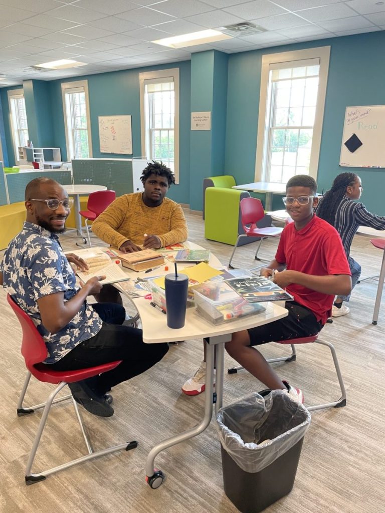 students and teacher sitting at a table