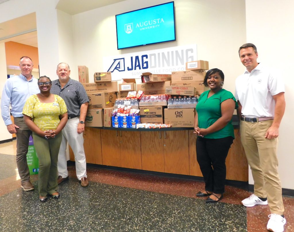 Group standing in front of food donations.