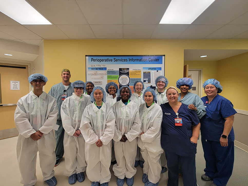Men and women posing for a picture in scrubs