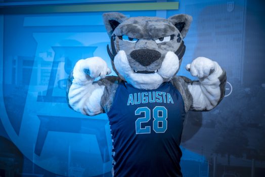 Augustus in a basketball jersey flexes his muscles