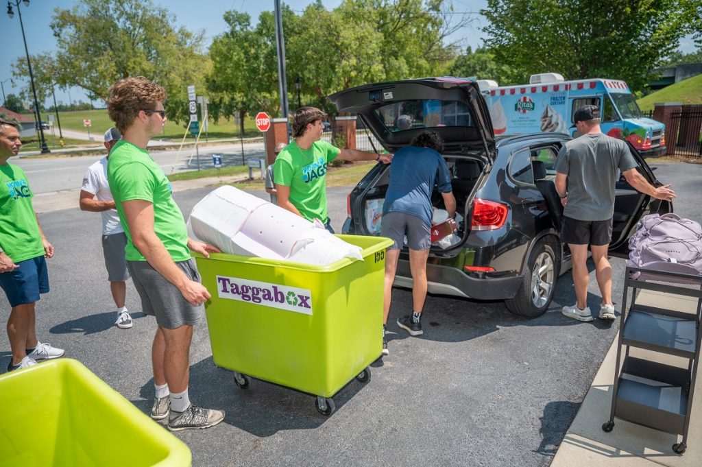 Student volunteers help new students unload and move in to their new place
