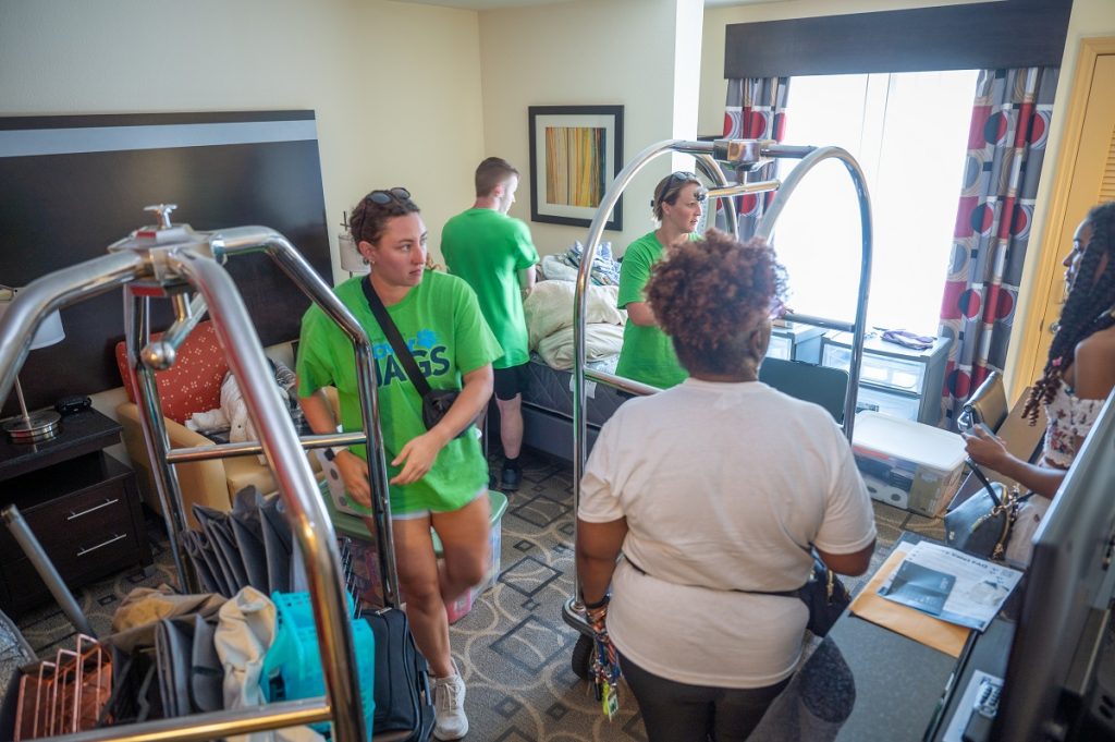 student volunteers assist new students move in to their new home