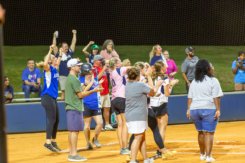 Men and women celebrating at home plate