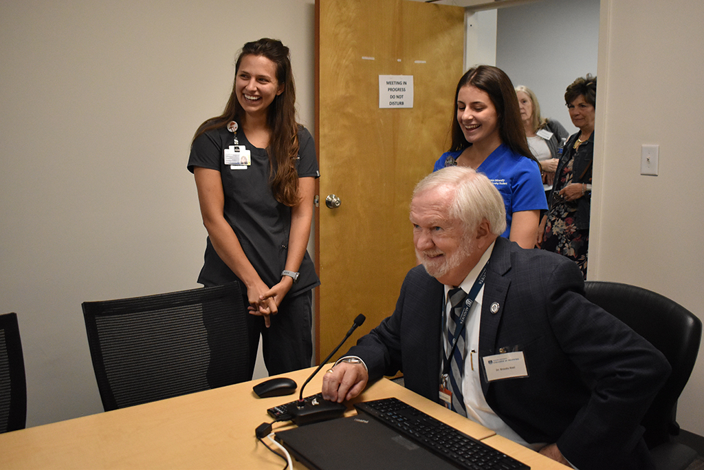 Man smiling with two women looking on