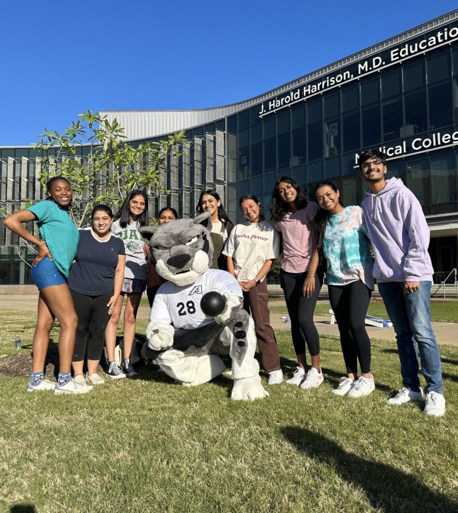 young men and women pose with Augustus, the mascot