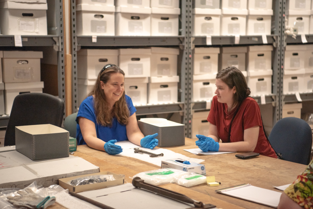 Woman surrounded by museum artifacts. 