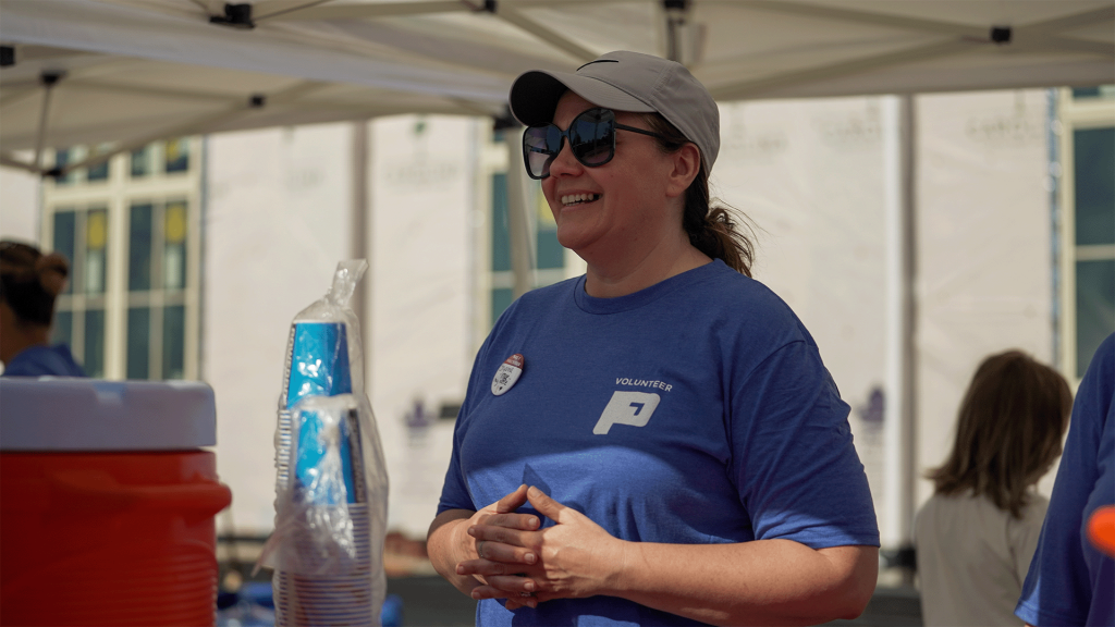 Volunteer smiles at water station.