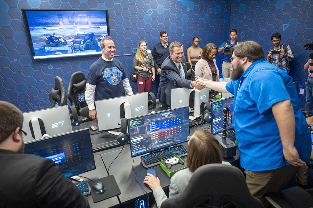 Men and women shaking hands in new facility