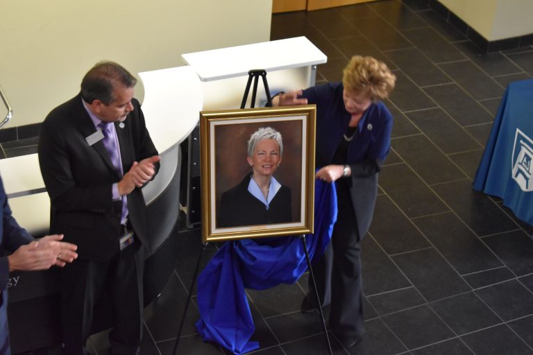 Kevin Velez and Debbie Layman unveil Dr. Marion's official portrait.