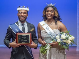 a man in a suit is crowned Mr. Augusta University and a woman in a ballgown is crowned Miss Augusta University