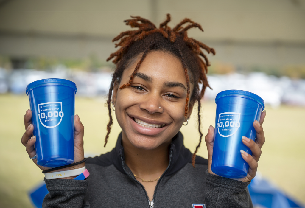 A woman poses with two tumblers