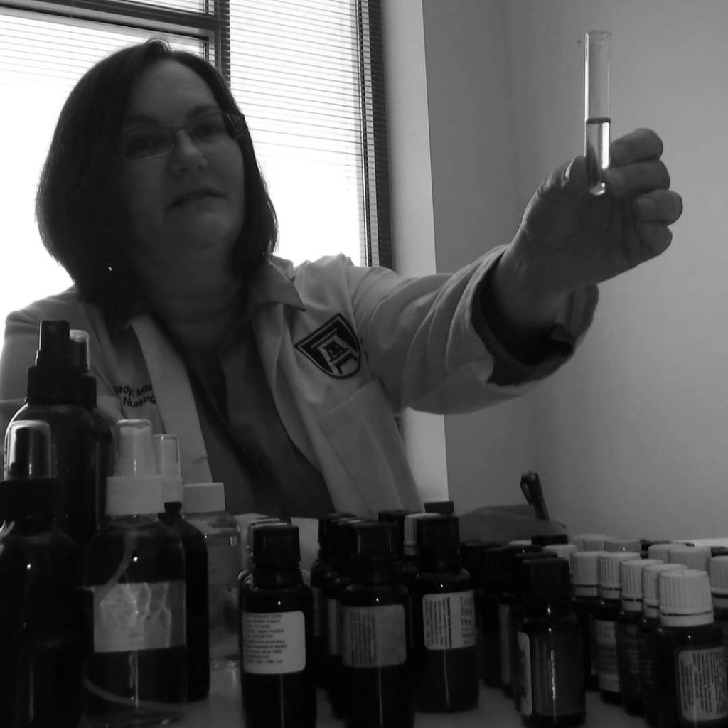 Black and white photo of Dr. Langley-Brady conducting research with essential oils
