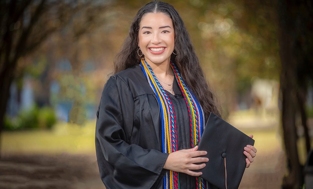 Woman smiling in graduation cap and gown